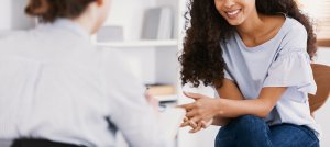 Image of a smiling woman meeting with a trauma therapist in Scotch Plains, NJ for food allergies and anxiety.