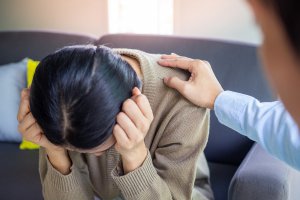 Image of a woman with her head down and a hand on her shoulder representing the support you can get from a Scotch Plains therapy intern. In Westfield, NJ counseling you can receive the same support from an intern as you can from a therapist.