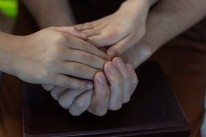A close up of a person holding the hand of their child. This could represent the support parent coaching in Scotch Plains, NJ can offer. Learn more about antiracism in Scotch Plains NJ and how trauma therapy in Scotch Plains, NJ can offer support. 