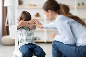 A scared child is being comforted by an EMDR therapist. Represents how emdr therapy for children has a goal to not retraumatize the children and will adapt to their developmental level to make if effective and comfortable.