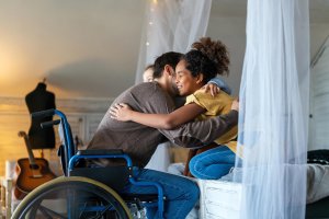 Shows a dad in his wheelchair hugging his children. Represents how emdr trauma therapy in scotch plains, nj will include parents to help support their children throughout the process.