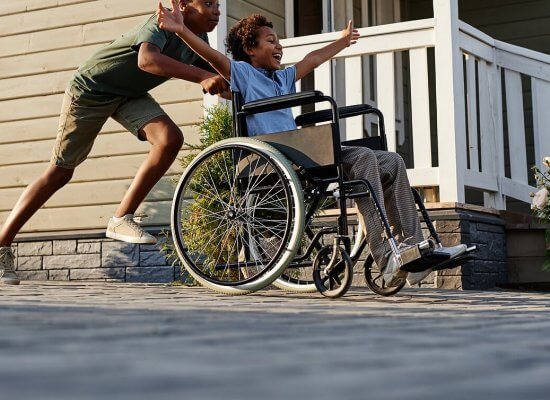 Shows an older brother pushing his younger brother in a wheelchair. Represents how emdr therapy for children can help them reprocess traumatic memories and help them move past them.