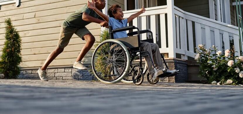 Shows an older brother pushing his younger brother in a wheelchair. Represents how emdr therapy for children can help them reprocess traumatic memories and help them move past them with services in Westfield NJ and Somerville NJ