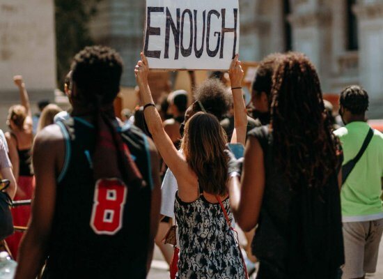 a group of protestors, one holding up a sign that reads, "Enough", protesting a high school with bullying and a system that has failed to keep it's students safe. Teens are looking for mental health help and teen therapy in Somerville, NJ and Fanwood, NJ and surrounding areas