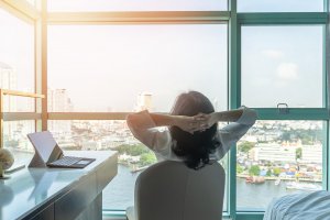 A woman sits with her hands behind her head while looking out the window. This could represent how online therapy in New Jersey can offer support from home. Contact an online therapist to learn more about Somerville NJ counseling and other services in the Scotch Plains and Branchburg, NJ areas.
