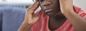 A close up of a black teen holding their temples. Learn how a trauma therapist in Scotch Plains, NJ can offer support with healing from narcissistic traits. Search for narcissist Scotch Plains, NJ for support via trauma therapy in Scotch Plains, NJ. 