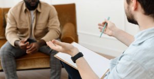 A man with a noteboard gestures while talking to a man sitting across from him. Learn more about the support that a culturally sensitive therapist in Scotch Plains, NJ can offer. Search “trauma therapist near me” to learn more about the support a trauma therapist in scotch plains, nj can offer. 