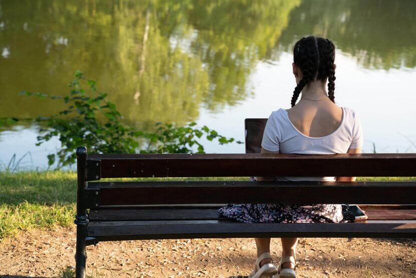 Image of a a teenage girl sitting on a bench. Which represents someone who could benefit from therapy for teens, or adolescent therapy in Branchburg, NJ. Where anxiety in teens can be addressed.