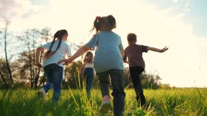 Image of 4 kids playing outside in the grass. Showing the joy children can have with support of therapy in Branchburg, NJ with a childrens therapists.