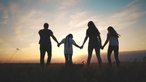 Image of a family of 4 walking together hand in hand. Showing a potential outcome of meeting with a therapist for counseling or therapy in Branchburg, NJ.