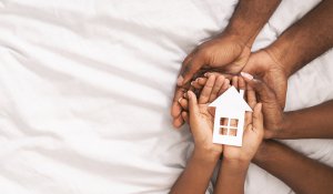 Man holds cutout of a house with their child. Looking to get your child the therapy they need in New Jersey? Visit us today to get more information about therapy for children.