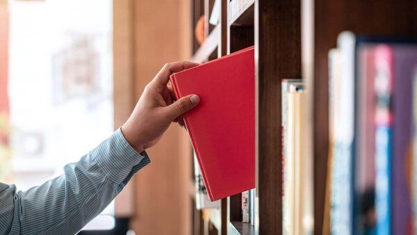 Man grabbing a red book. Trauma therapy in Branchburg or Scotch Plains, NJ can help you work through your trauma. Reach out to a trauma therapist today!