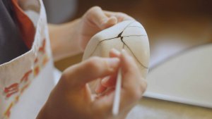 Woman paints over cracked bowl. Feeling the pressure of not practicing self-care? Trauma therapists in New Jersey can help heal those wounds. Call today!