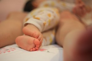 A close up of a sleeping toddler’s feet next to their parent. A child therapist in Branchburg, NJ can offer parenting help for new parents. Learn more about child therapy in Branchburg, NJ, and other services today.