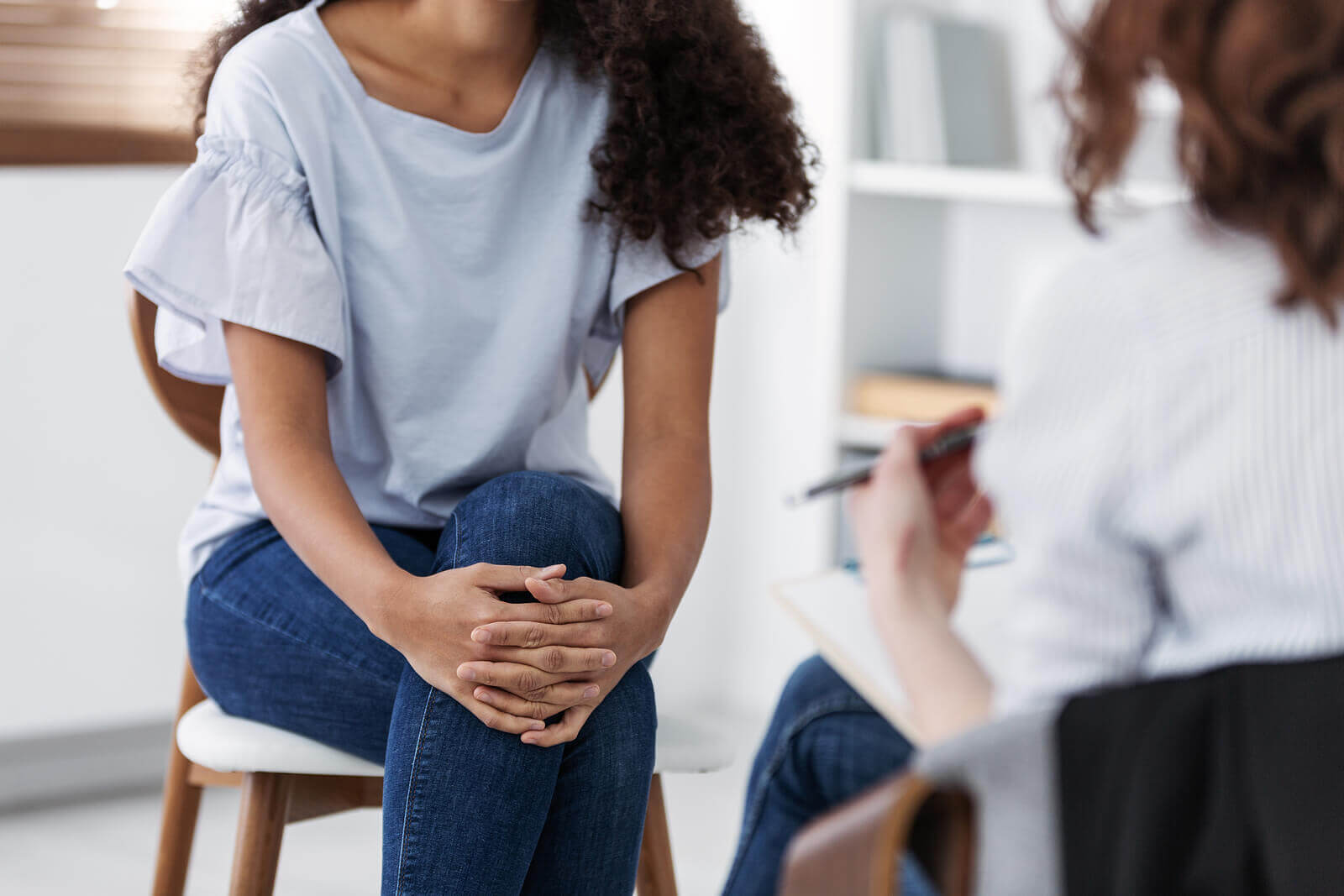 A woman sits across from a woman holding a clipboard. This could represent the benefits of meeting with a trauma theapist in Scotch Plains, NJ. Learn more about Scotch Plains therapy by searching for "therapist Branchburg, NJ" today.