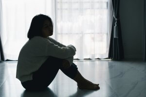 Image of a child sitting alone in a dark room while looking out a window. This could show how selective mutism can affect how kids socialize at. Learn how child therapy in New Jersey can offer support via EMDR for children. Contact a child therapist in Branchburg, NJ to learn more today.
