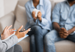 therapist talking to a couple on a couch. do you need help working through the aftermath of wedding planning? Look for a couples therapist in Scotch Plains or Branchburg, NJ.