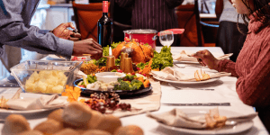 Woman watching man light a candle on a table set for holiday dinner. A therapist in Branchburg, New Jersey can help you manage triggers related to toxic family members.