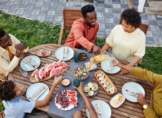 A family toast while talking around a dinner table. Learn how counseling in Branchburg, NJ can offer support with therapy Branchburg, NJ. Search for online group therapy in New Jersey today.