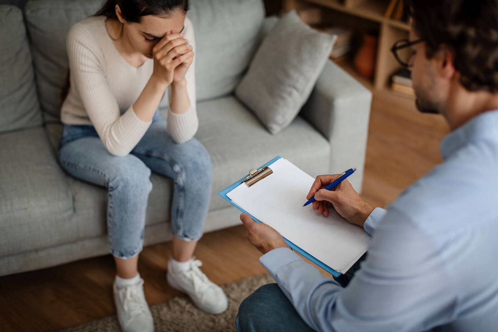 A woman hands her head while sitting across from a person with a clipboard. This could represent the support an equestrian therapist Branchburg, NJ can offer. Learn more about the help equestrian therapy in New Jersey can offer by searching for EMDR therapy in Branchburg, NJ today.