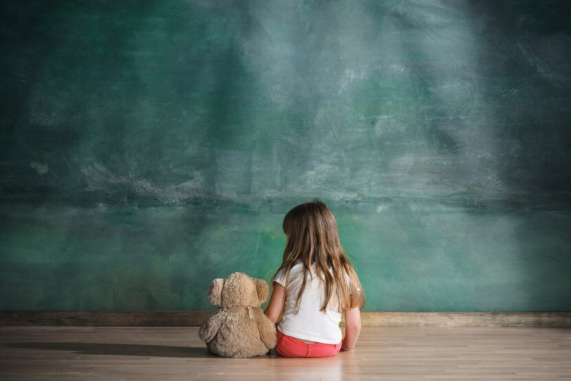 A child sits alone with a bear while facing a wall. Learn how a trauma therapist in Scoth Plains, NJ can offer support with parenting help in Scotch Plains, NJ or addressing past trauma. Search for trauma therapy in Branchburg, NJ today.