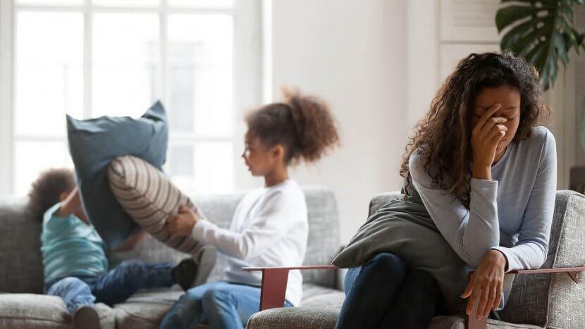 A mother covers her face as her kid’s pillow fights in the background. Learn how a moms support group in Branchburg, NJ can offer support with online therapy in New Jersey and other services. Contact a group therapist in Scotch Plains, NJ to learn more.