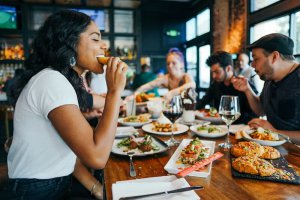 People enjoying a meal at a restaurant, highlighting the social challenges of food allergy anxiety. Counseling services in Branchburg NJ provide strategies for dining out safely while advocating for food allergy needs and supporting spouses through anxiety-producing situations.