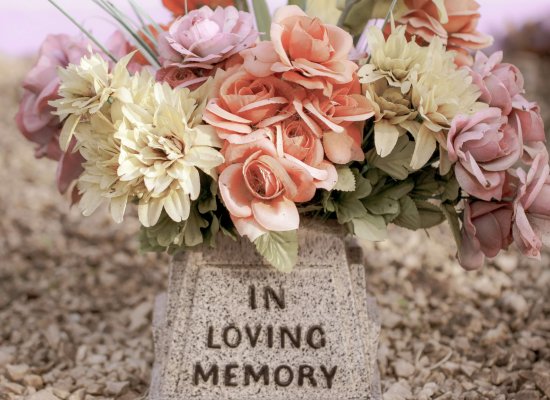 A gentle memorial arrangement of soft pink, peach, and cream flowers rests beside a stone marker reading "In Loving Memory," representing the grieving process. What does grieving mean? It encompasses emotional, physical, and spiritual responses to loss. Grief counseling NJ provides professional support for grieving symptoms in Branchburg, NJ. Loss and grief in Scotch Plains, NJ affects many families seeking compassionate guidance. Grief counseling NJ helps address grieving symptoms such as sadness, difficulty concentrating, and emotional waves.