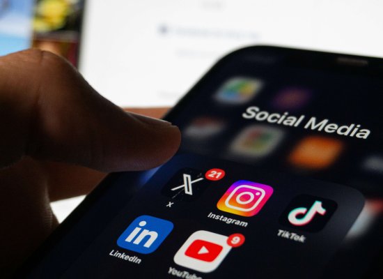 Hand hovering over social media apps including Instagram, YouTube, TikTok, and LinkedIn, illustrating the impact of social media on mental health in Scotch Plains. Serving Scotch Plains, Branchburg, and Somerville, Brave Minds Psychological Services offers grief counseling to help process collective grief from distressing current events.