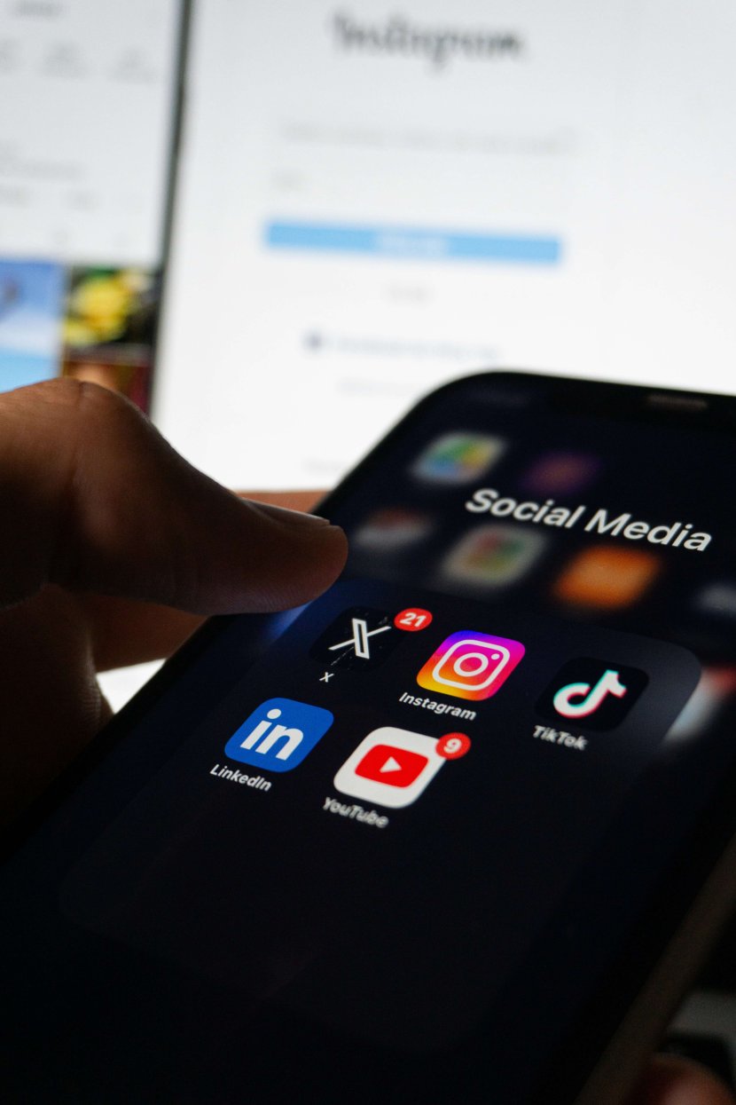 Hand hovering over social media apps including Instagram, YouTube, TikTok, and LinkedIn, illustrating the impact of social media on mental health in Scotch Plains. Serving Scotch Plains, Branchburg, and Somerville, Brave Minds Psychological Services offers grief counseling to help process collective grief from distressing current events.