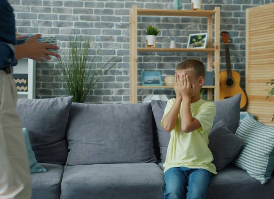 A young boy covering his face on a couch, reflecting the emotional struggle of therapy resistant children in NJ. Serving parents in Scotch Plains, Branchburg, and Somerville looking for parenting advice and parent coaching in Scotch Plains, NJ.