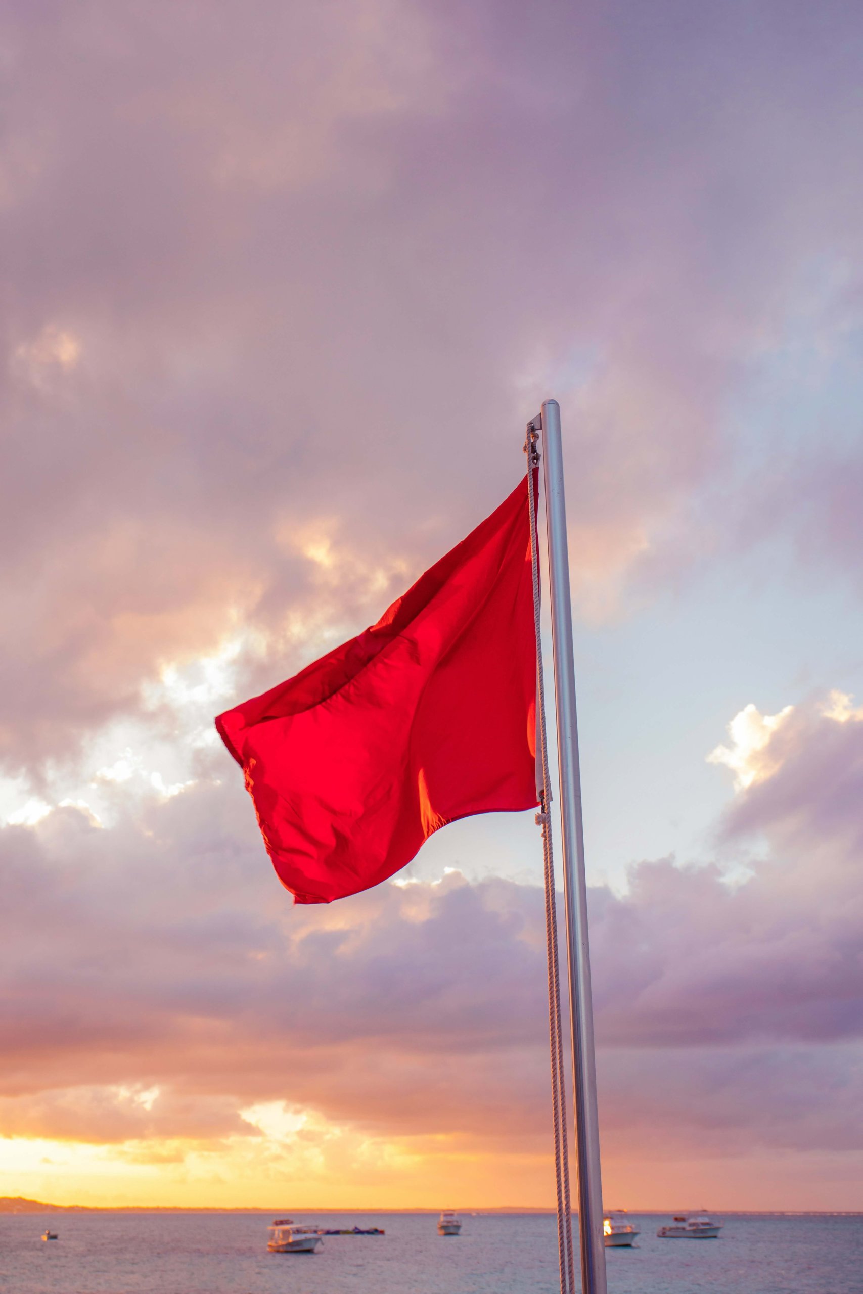 A red flag waving at sunset, symbolizing warning signs to watch for when dating with food allergies and anxiety in Branchburg, NJ. Serving Somerville, Scotch Plains, and surrounding NJ communities with food allergy anxiety therapy and support.