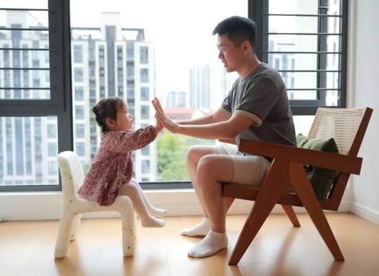 A father and young daughter share a validating high-five moment in Branchburg. Serving Branchburg, Somerville, and the surrounding NJ community with child therapy and parent coaching focused on emotional regulation skills.