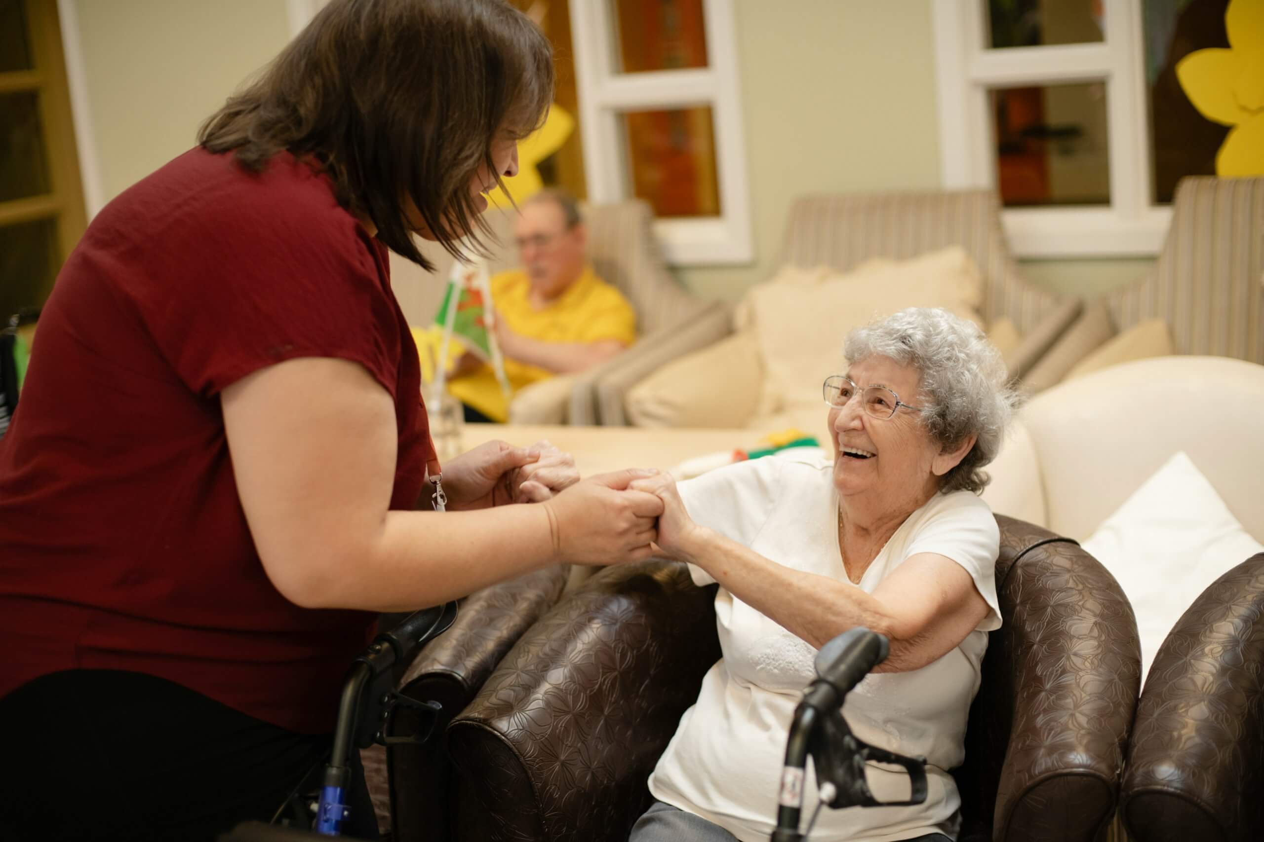 A caregiver gently holds the hands of a smiling older woman in Scotch Plains. Serving Scotch Plains, NJ families searching for guidance on how to support someone with cancer through warmth, presence, and connection.